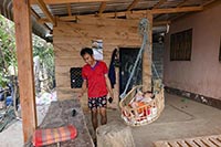 Padre e bambino in culla nella loro casa a Tomotha sul Mekong