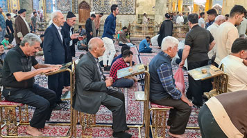 Fedeli assisi in preghiera presso il santuario dell'Imam Hussein a Karbala