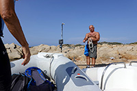 L'aiuto-capitano tende la gomena per un sicuro approdo a Porto Madonna (isola di Santa Maria)