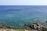 Il mare davanti al faro di Punta Filetto all'isola Santa Maria, al largo il faro dell'isola di Barrettinelli di Fuori