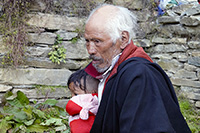 Anziano con bambino al gompa di Gonhgye