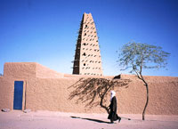 Un touareg passa accanto al minareto di Agadez