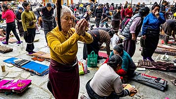 Devoti tibetani si prostrano di fronte all'ingresso del Jokhang