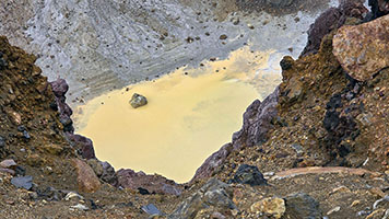 Dettaglio del lago sulfureo sul fondo del cratere di Meakan