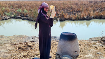 Cottura del pane arabo in un forno presso la palude di Aka Madans