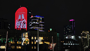 La torre 'Temir Zholy' di notte con la sua enorme e cangiante insegna pubblicitaria