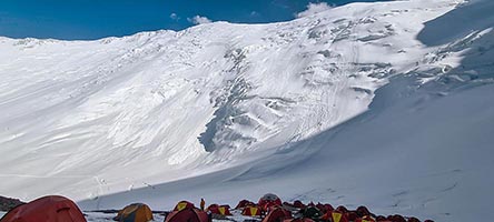 Il campo due già in ombra davanti alla parete nord del picco Lenin