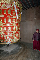 Monaca accanto alla ruota di preghiara diRachen gompa