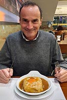 Giuseppe affronta un'imponente Francesinha in un ristorante di Porto
