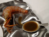 Cucchiaio di succo di testa di gambero con chele di gambero croccanti e coda cruda