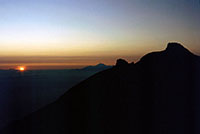 Il sole spunta all'orizzonte dalla vetta del Gunung Agung